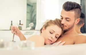 Young happy successful couple enjoying an hot bath in the jacuzzi